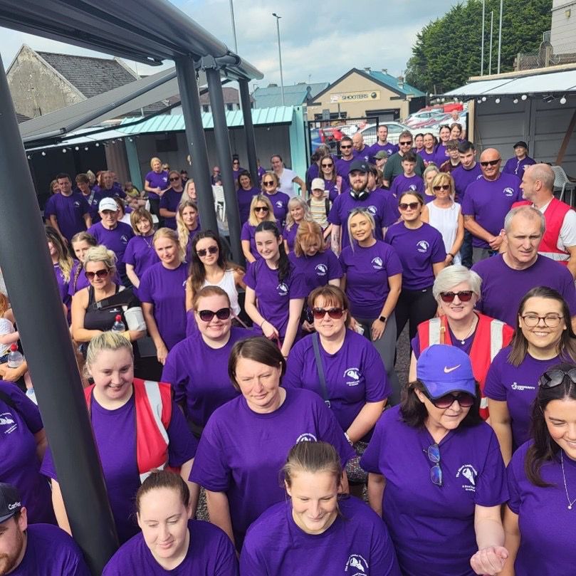 Large community group wearing purple Niamh Louise Foundation t-shirts at a fundraising event